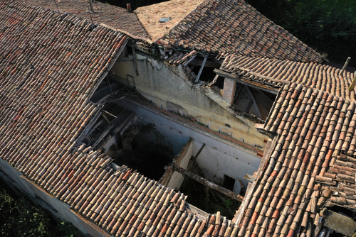 Old,Damaged,Tiled,Roof,With,Broken,Tiles,And,A,Hole